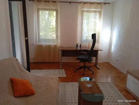 Living room with a desk and a sofa. - image 3