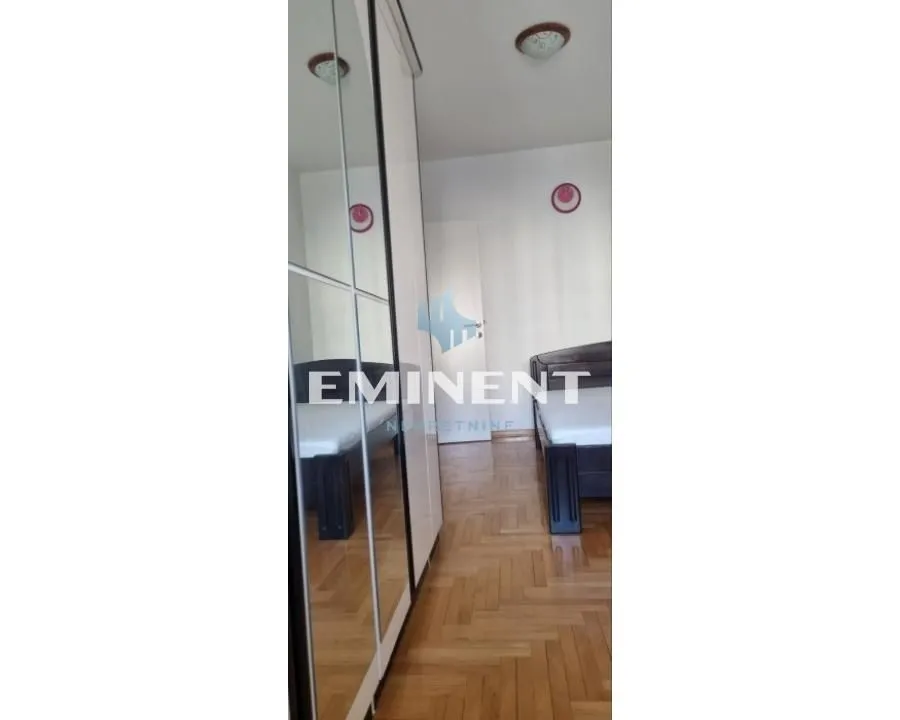 Bedroom with a bed and a large mirrored wardrobe.