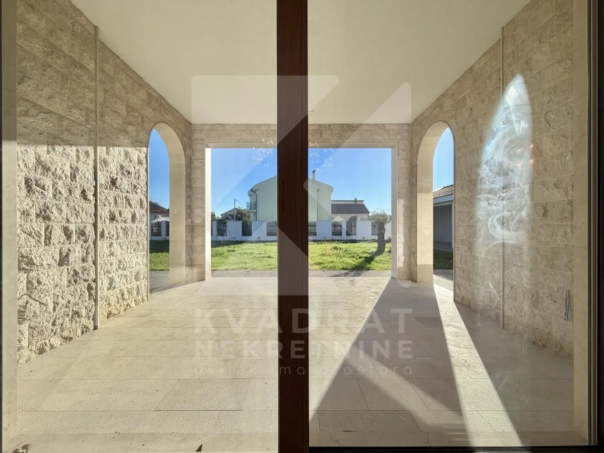 Covered stone-paved terrace with a view of the courtyard.