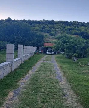 Dvorište sa betonskom ogradom i travnatim prilazom. - image 4