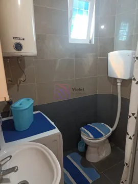 Small bathroom with a shower, toilet, washbasin, and water heater. - image 2