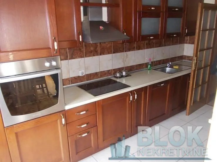 Kitchen equipped with wooden cabinetry, built-in oven and hob.