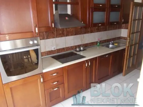 Kitchen equipped with wooden cabinetry, built-in oven and hob. - image 2
