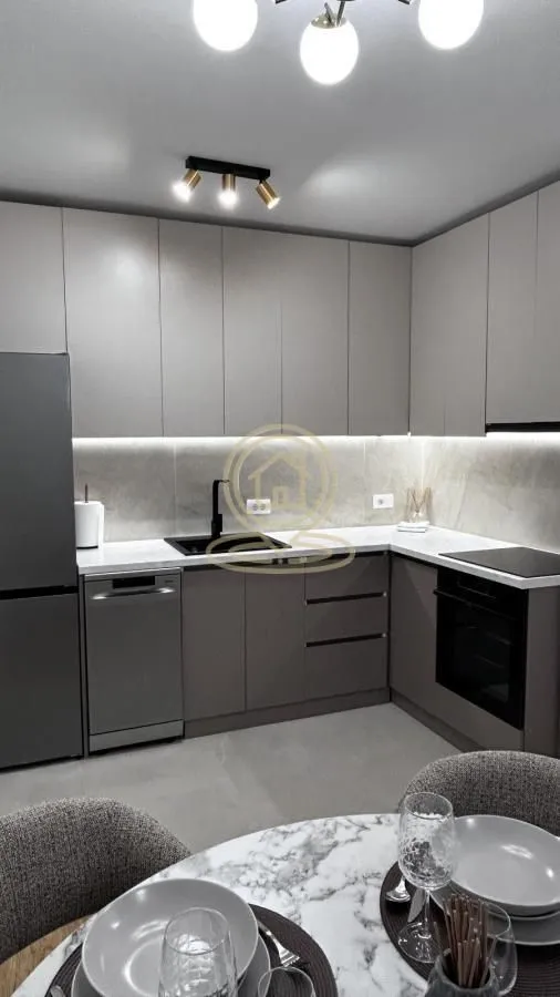 Modern kitchen with grey cabinetry and built-in appliances.