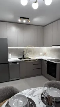 Modern kitchen with grey cabinetry and built-in appliances. - image 8