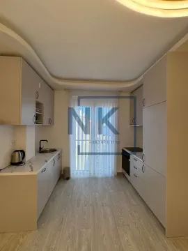 Moderna kuhinja sa ugradnim elementima i balkonskim vratima. - image 4