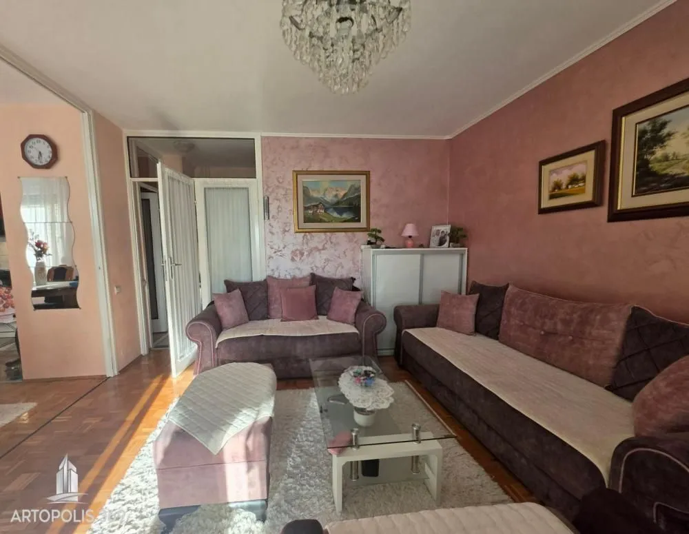 Dnevna soba sa garniturom za sedenje i lusterom.