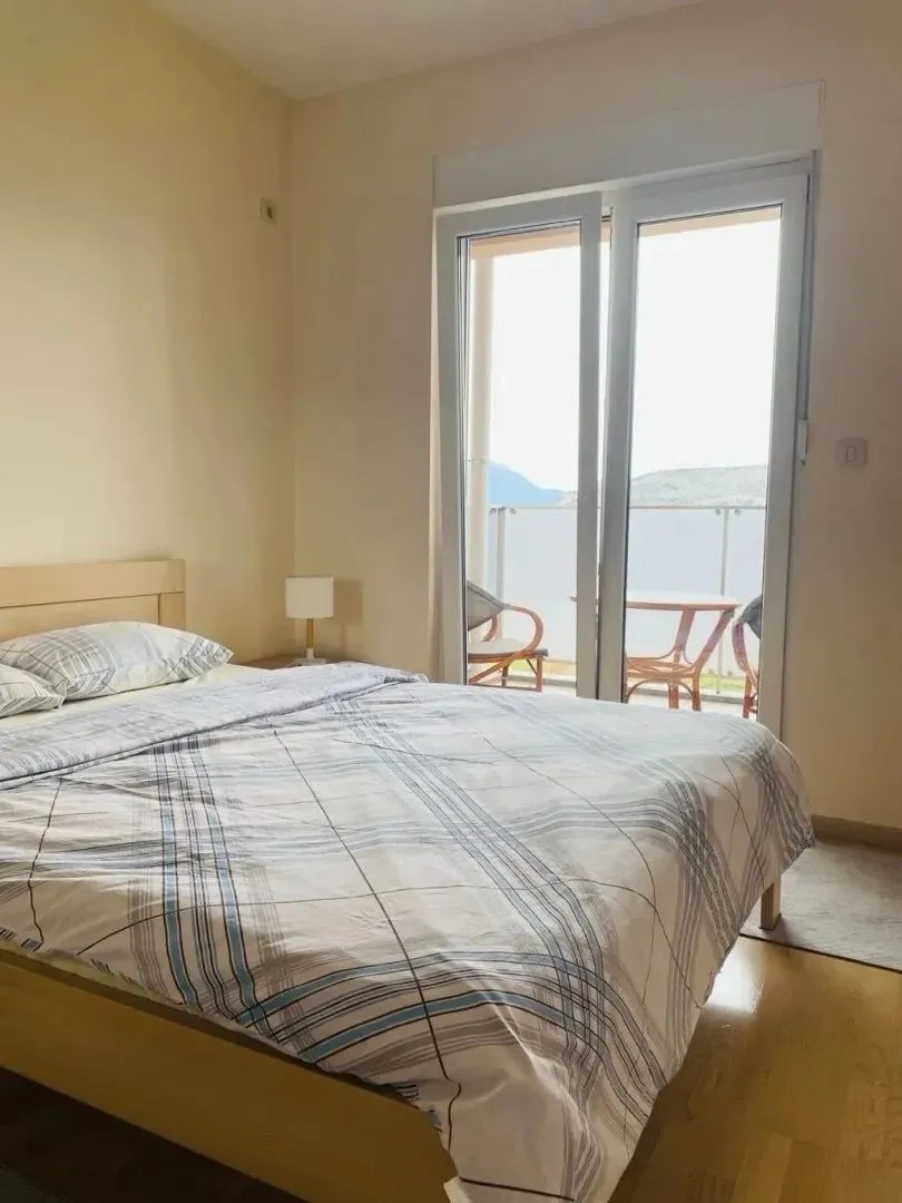 Furnished bedroom with a double bed and access to a terrace with a view.
