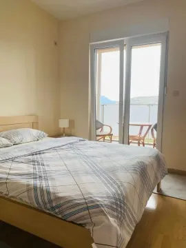 Furnished bedroom with a double bed and access to a terrace with a view. - image 9