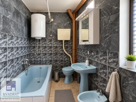 Kupatilo sa plavim sanitarijama, kadom i tamnim mermernim pločicama. - image 21
