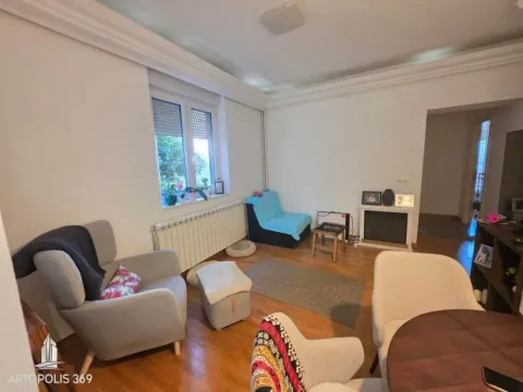 Dnevna soba sa nameštajem, drvenim podom i prozorom. - image 2
