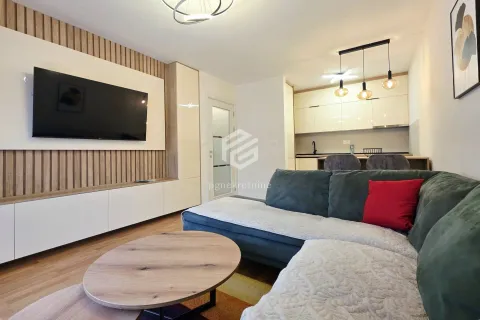 Living room with sofa, TV and a view of the kitchen in the background. - image 10