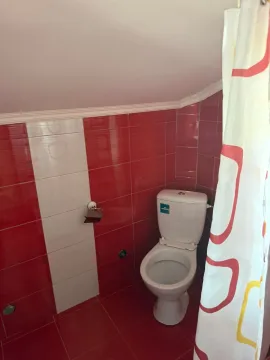 Small bathroom with red and white tiles and a toilet. - image 13