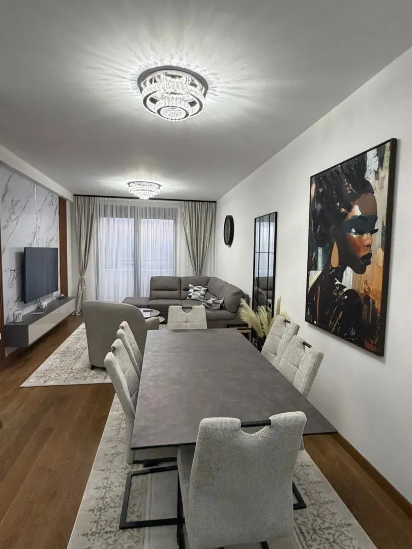 Prostrani dnevni boravak sa trpezarijom i modernim namještajem.