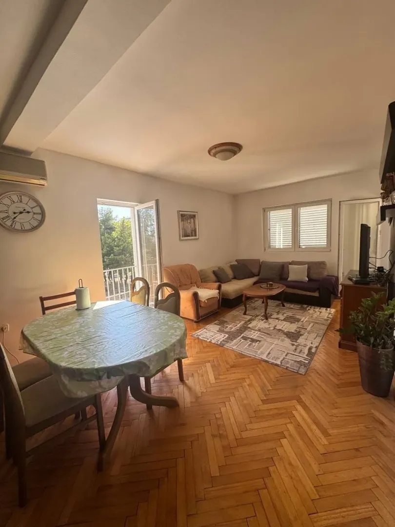 Living room with dining area and parquet flooring.