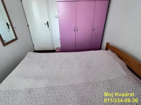 Spavaća soba sa bračnim krevetom i ljubičastim garderoberom. - image 10
