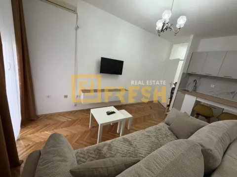 Dnevna soba sa garniturom, televizorom i kuhinjom u pozadini. - image 4
