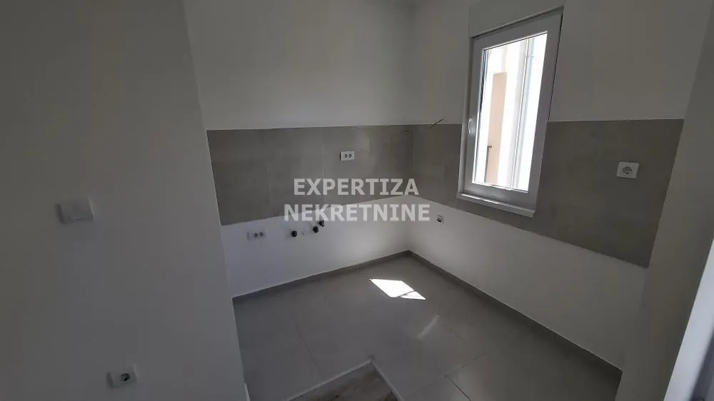 Empty room intended for a kitchen with ceramic tiles and a window.