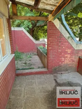 Natkrivena terasa sa pogledom na dvorište i ciglenim zidovima. - image 10