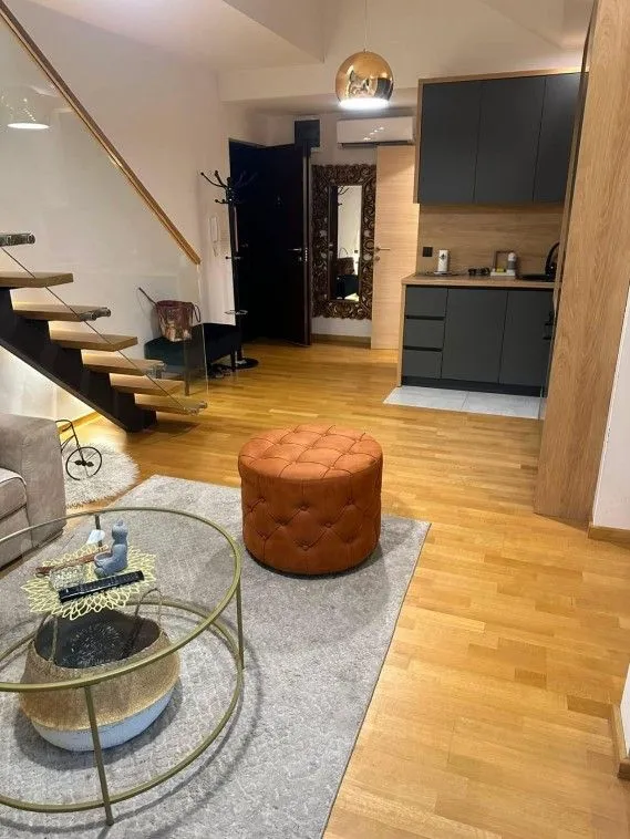 Dnevni boravak sa kuhinjom i stepeništem u stanu.