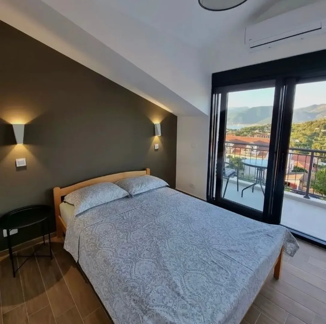 Furnished bedroom with a double bed and access to a balcony with a view.