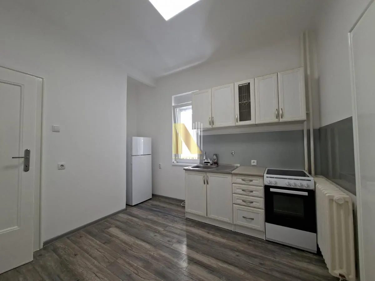 Small bright kitchen with white cabinets, stove, and refrigerator.
