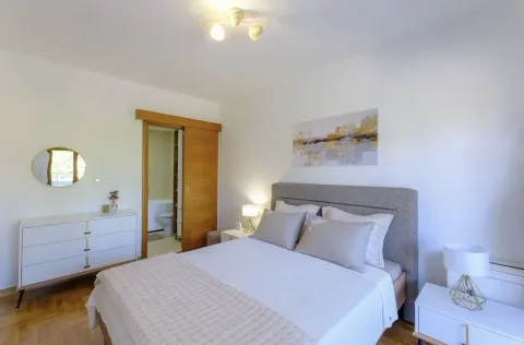 Bright bedroom with a double bed and entrance to the bathroom. - image 3