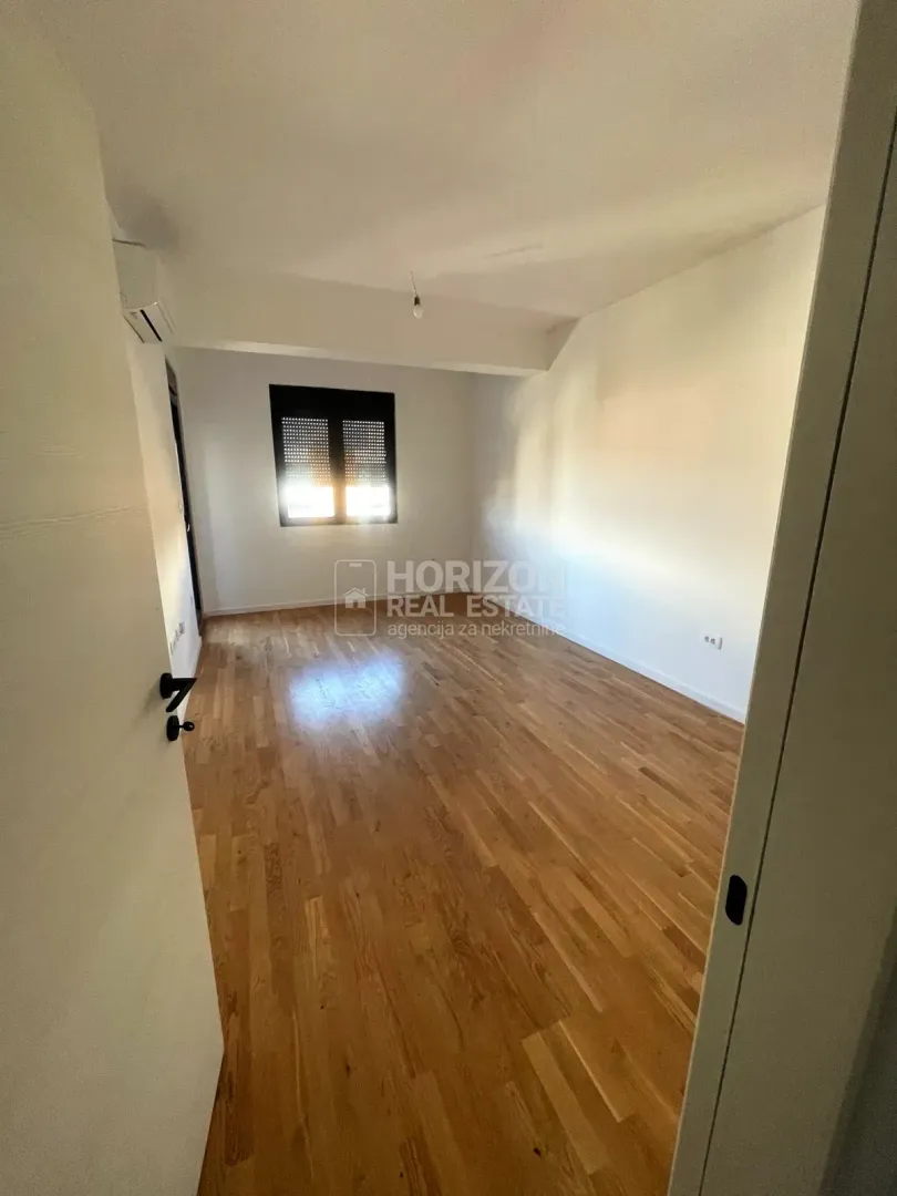 Empty room with parquet flooring and white walls.