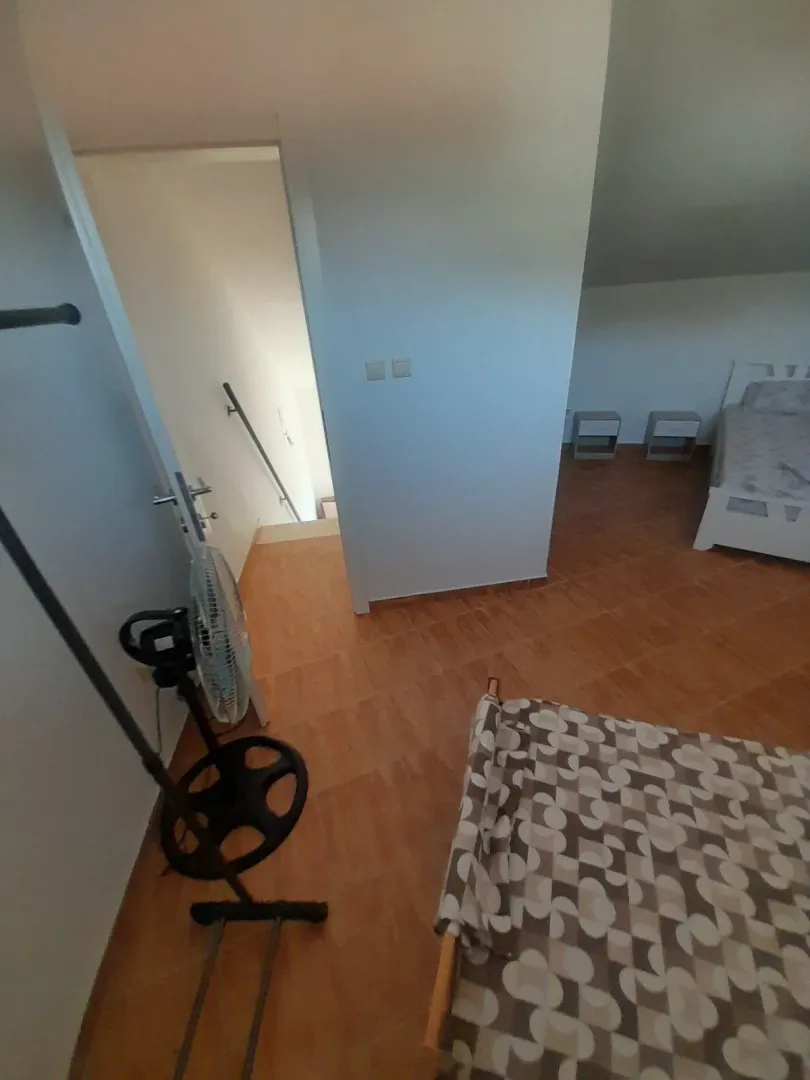 Attic bedroom with beds and floor tiles.