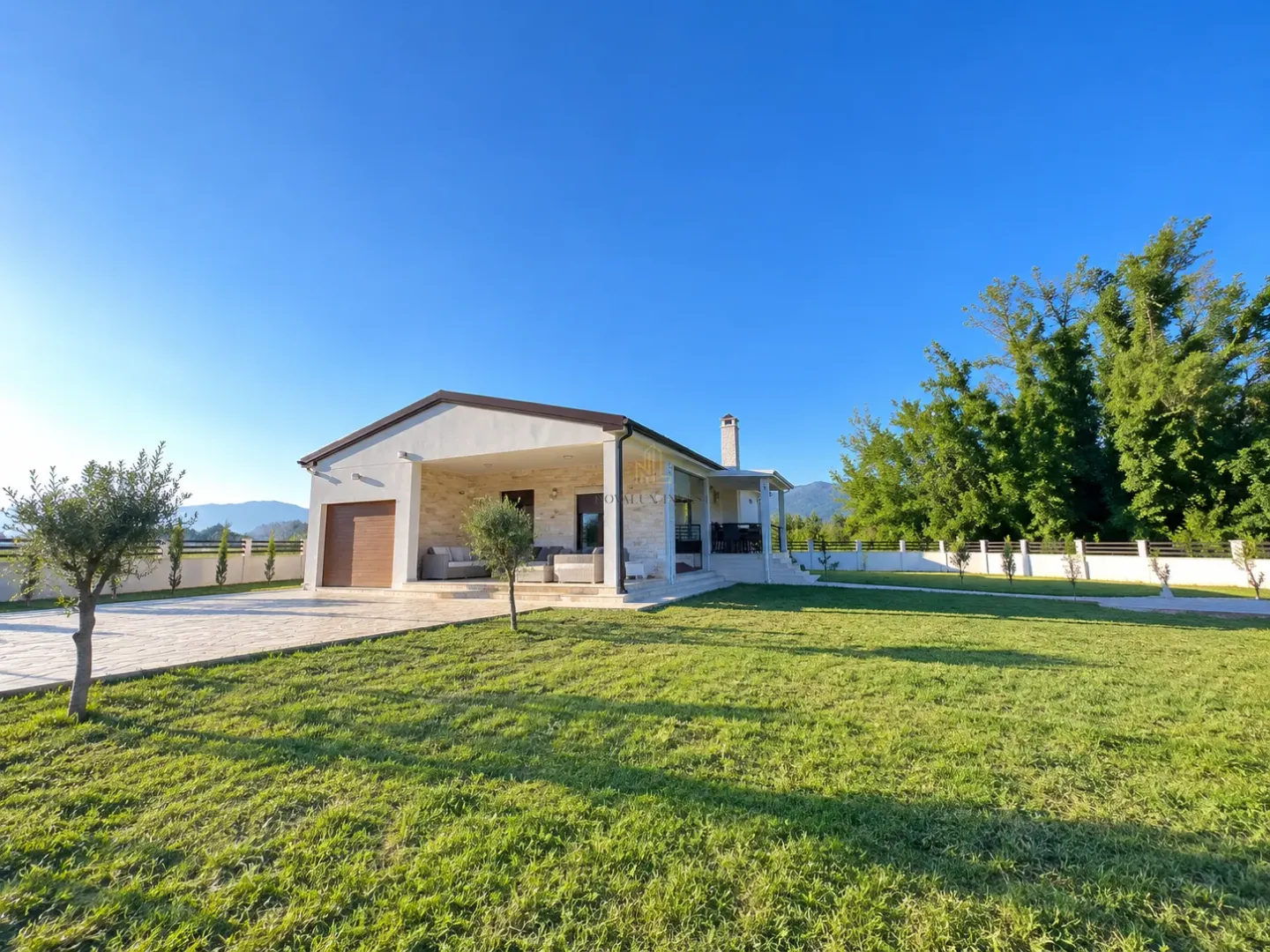 View of the courtyard and the house facade with a manicured lawn.