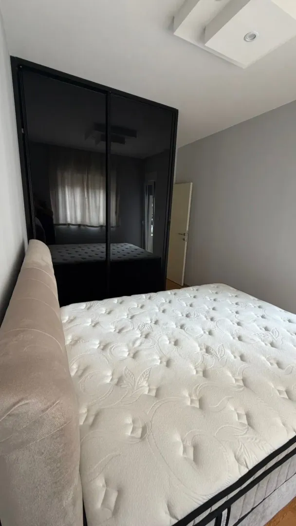 Bedroom with a double bed and a large mirrored wardrobe.