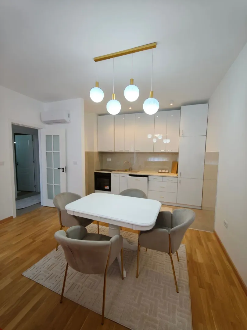 Modern kitchen with dining area and white cabinets.