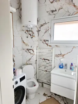 Manje kupatilo sa mermernim pločicama, umivaonikom, WC šoljom i veš mašinom. - image 13