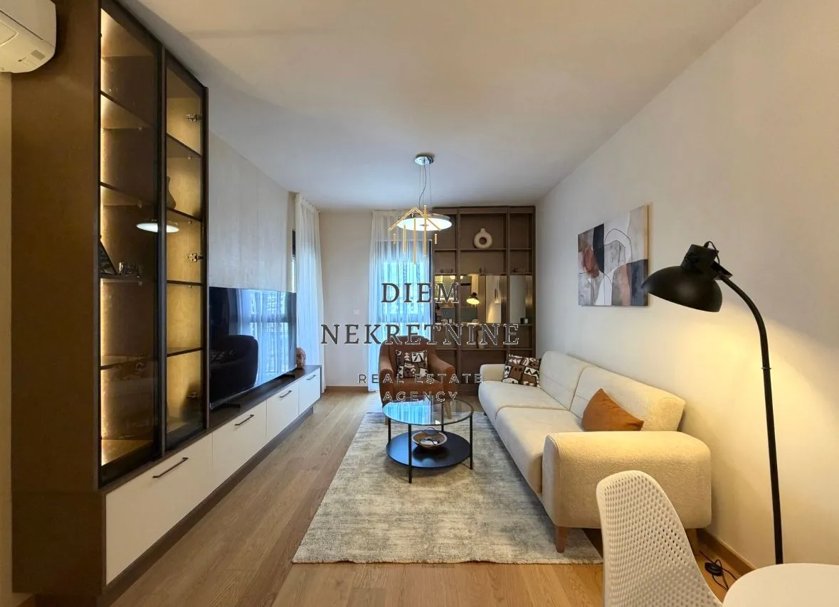 Modern and tidy living room with sofa, TV unit, and shelving.