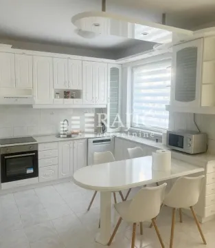 Bright white kitchen with a dining table and chairs. - image 14