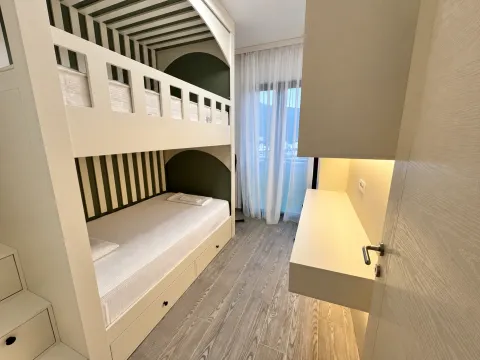 Children's bedroom with a bunk bed and a desk. - image 8