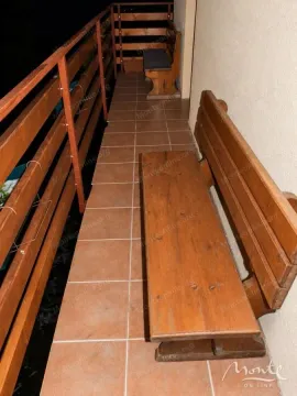 Long balcony with wooden benches and railing. - image 21