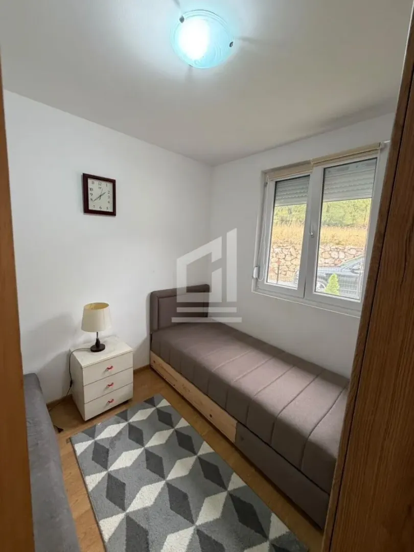 Smaller bedroom with a pull-out bed and a nightstand.