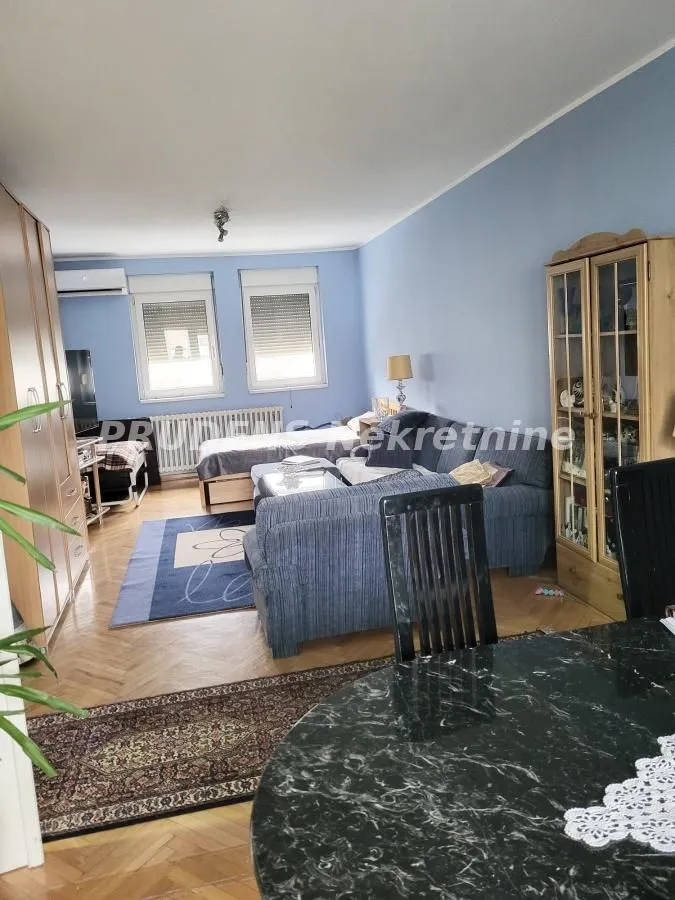 Living room with seating furniture, dining table, and wardrobes.