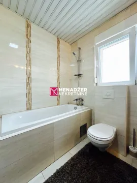 Kupatilo opremljeno kadom, wc šoljom i prozorom. - image 10
