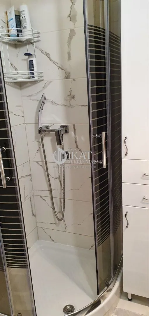 Bathroom with a shower cabin and a white bathroom cabinet.