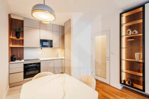 Modern kitchen with fitted units and a dining table. - image 2
