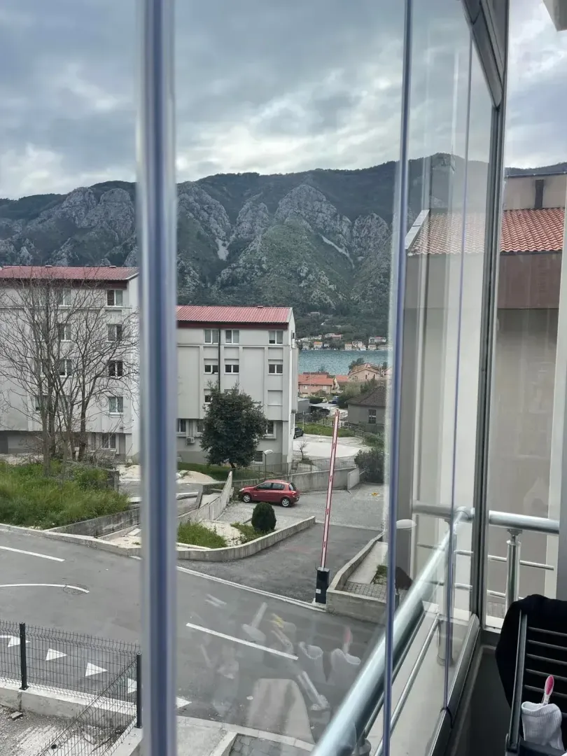 View from the balcony overlooking surrounding buildings, mountains, and the sea.