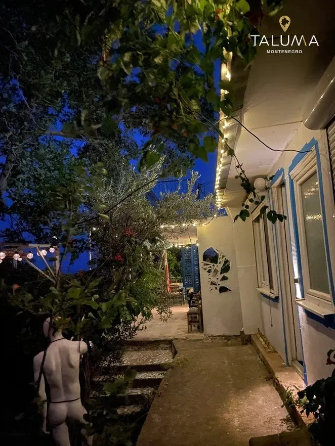 Osvijetljeno dvorište i spoljašnji dio kuće u večernjim satima.