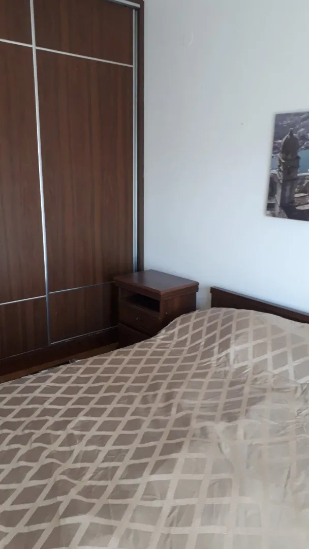 Spavaća soba sa bračnim krevetom, noćnim stočićem i ugradnim garderoberom.