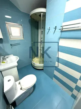 Kupatilo sa tuš kabinom, umivaonikom, WC šoljom i plavim pločicama. - image 8