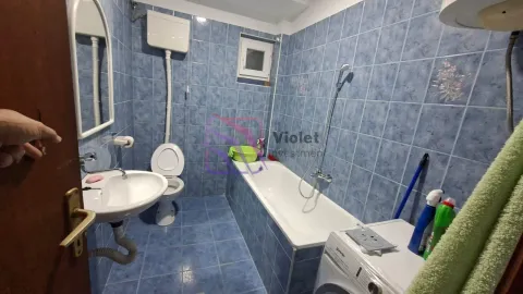 Tiled bathroom with a bathtub, washbasin, and toilet. - image 15