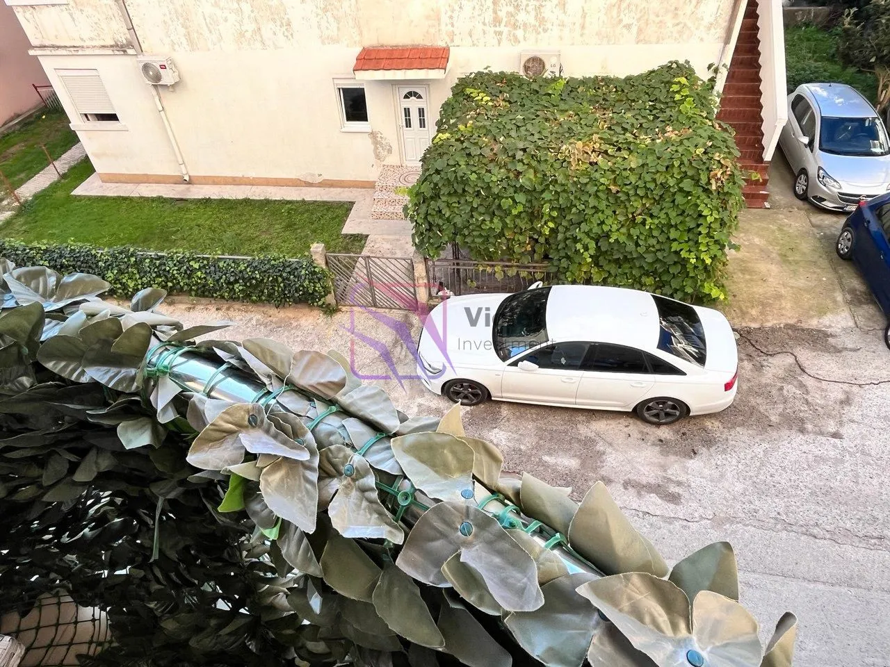 Pogled sa terase na dvorište i parking ispred kuće.