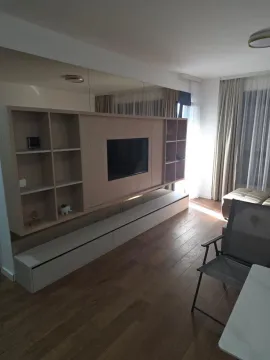 Dnevni boravak sa velikom drvenom policom za TV i ogledalima na zidu. - image 5