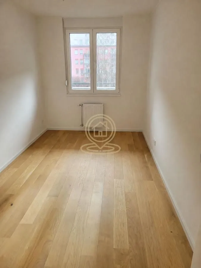 Prazna soba sa drvenim podom i prozorom.